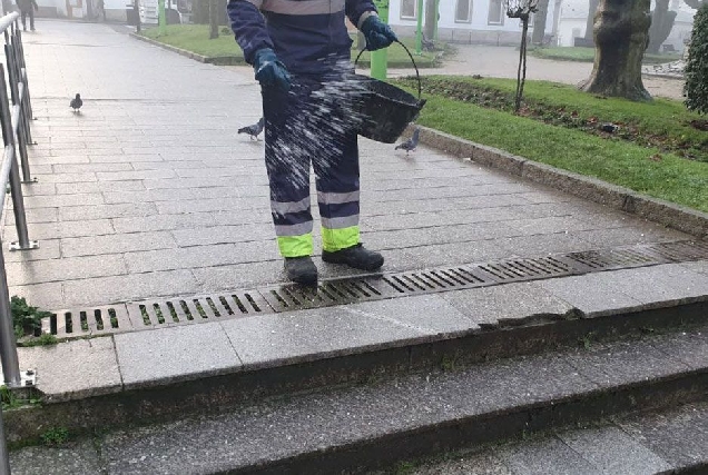 operario botando sal rúas cidade